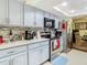 Kitchen features gray cabinets, stainless appliances, and backsplash and a view to the dining room at 12529 Shadow Ridge Blvd, Hudson, FL 34669