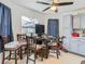 Cozy dining area with a round table, ceiling fan, and view of the backyard through a bright window at 12529 Shadow Ridge Blvd, Hudson, FL 34669