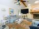 Inviting living room featuring a stone fireplace, a large TV, and comfortable furnishings at 12529 Shadow Ridge Blvd, Hudson, FL 34669