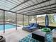 Inviting covered patio with lounge chairs overlooks the sparkling pool and landscaped backyard at 12529 Shadow Ridge Blvd, Hudson, FL 34669