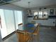 Cozy dining area with a modern light fixture, a large window and sliding glass doors for natural light and ventilation at 13618 Stacey Dr, Hudson, FL 34667