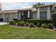Charming single-story home featuring a well-manicured lawn, an American flag, and a neatly landscaped garden at 18049 Tarrington Pl, Hudson, FL 34667