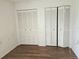 Bedroom with hardwood floors and double closets offering ample storage space at 4912 Enfield Ct, New Port Richey, FL 34655