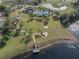 Aerial view of the community amenities, including the pool, playground, dock, lake, and walking paths at 13822 Bee Tree Ct, Hudson, FL 34669