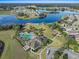 Beautiful aerial view of the community pool, playground, lake, and surrounding homes and lush landscaping at 13822 Bee Tree Ct, Hudson, FL 34669