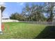 Expansive backyard featuring lush green grass and a white picket fence, perfect for outdoor activities at 13822 Bee Tree Ct, Hudson, FL 34669
