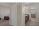 Well-lit bathroom with a vanity featuring granite countertops and a view into an adjacent bedroom at 13822 Bee Tree Ct, Hudson, FL 34669