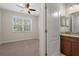 Bright bedroom featuring a double door bathroom and a large window at 13822 Bee Tree Ct, Hudson, FL 34669