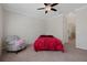 Bedroom featuring a ceiling fan, a chair and a doorway leading into a bathroom at 13822 Bee Tree Ct, Hudson, FL 34669