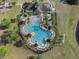Aerial perspective of the community pool area, featuring the pool, clubhouse, and well-manicured landscaping at 13822 Bee Tree Ct, Hudson, FL 34669