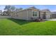 A well-manicured lawn surrounds a tan home with stone accents; featuring well-maintained siding and fencing at 13822 Bee Tree Ct, Hudson, FL 34669