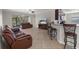 Open concept living room with tile flooring, a comfortable sofa, and kitchen with breakfast bar in the background at 13822 Bee Tree Ct, Hudson, FL 34669