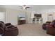 Cozy living room features tile floors, modern fan, and a glimpse of the kitchen with barstool seating at 13822 Bee Tree Ct, Hudson, FL 34669