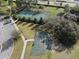 Aerial view of the tennis court, basketball hoop, and surrounding parking area at 13822 Bee Tree Ct, Hudson, FL 34669