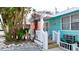 Inviting bright blue exterior with a white pergola covered front porch and lush tropical landscaping at 1603 N Gulf N Dr # 30, Bradenton Beach, FL 34217