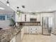Bright kitchen features granite countertops, stainless steel appliances, and ample cabinet storage at 3259 Hilary Cir # 1C, Palm Harbor, FL 34684
