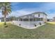 Backyard featuring screened-in lanai, well-maintained lawn and tropical landscaping at 4332 Lamson Ave, Spring Hill, FL 34608