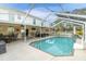 View of the backyard featuring a screened-in pool and patio with dining and lounging furniture at 4332 Lamson Ave, Spring Hill, FL 34608