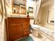 Well-lit bathroom with updated vanity, granite countertop, and tub with shower at 8111 Merrimac Dr, Port Richey, FL 34668