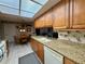 Bright kitchen with granite countertops, wood cabinets, and tiled flooring at 8111 Merrimac Dr, Port Richey, FL 34668