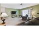 Cozy living room features neutral carpet, large window with curtains, and comfortable recliner seating at 8446 Braganza St, Spring Hill, FL 34608