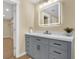 Contemporary bathroom vanity with gray cabinets, quartz countertop, and a backlit mirror at 9617 Norchester Cir, Tampa, FL 33647
