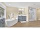 Beautiful bathroom featuring a soaking tub, glass shower, and modern vanity with an illuminated mirror at 9617 Norchester Cir, Tampa, FL 33647