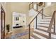 Bright foyer featuring wood floors, open staircase, and view to office space at 9617 Norchester Cir, Tampa, FL 33647