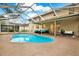 Backyard pool with a screened-in enclosure and outdoor seating area at 9617 Norchester Cir, Tampa, FL 33647