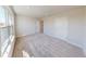 Sun-filled bedroom with plush carpeting, large window, and convenient access to an adjacent room at 10126 Zennia Ln, Parrish, FL 34219
