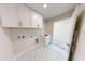 Bright laundry room with white cabinets, a sink, and modern fixtures for added convenience at 10126 Zennia Ln, Parrish, FL 34219