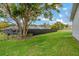 Backyard features a privacy fence, large tree, and view of the screened-in pool at 10200 Sunburst Ct, Spring Hill, FL 34608