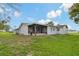 Backyard with a screened-in patio and lush green grass at 10200 Sunburst Ct, Spring Hill, FL 34608