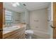 A bright bathroom features a shower-tub, a large mirror and a neutral-toned vanity at 10200 Sunburst Ct, Spring Hill, FL 34608