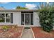 Close-up of an entryway showcasing a secure screen door and a walkway lined with decorative mulch at 10200 Sunburst Ct, Spring Hill, FL 34608