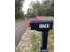 Street view of a black mailbox with the house number 11743 next to a quiet dirt road at 11743 Purdue St, New Port Richey, FL 34654