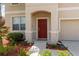 Close up of a red front door with porch and landscaping at 12307 Duckett Ct, Spring Hill, FL 34610