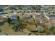 Aerial view showcasing well-maintained houses with pools, green lawns, and mature trees in a quiet neighborhood at 14215 Presteign Ln, Spring Hill, FL 34609