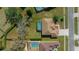 An overhead view reveals a beautiful home with a screened pool, well-kept lawn, and mature trees at 14215 Presteign Ln, Spring Hill, FL 34609
