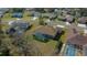 A peaceful neighborhood from above features houses with private pools, enclosed patios, and manicured lawns under a sunny sky at 14215 Presteign Ln, Spring Hill, FL 34609