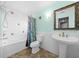 Bright bathroom featuring a pedestal sink, decorative tiled tub, and stylish fixtures at 14215 Presteign Ln, Spring Hill, FL 34609