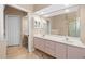Bathroom with tile floor, double sinks, large mirror, and walk-in shower at 14215 Presteign Ln, Spring Hill, FL 34609