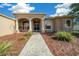 Inviting home exterior with an arched entryway, manicured landscaping, and a charming front walkway at 14215 Presteign Ln, Spring Hill, FL 34609