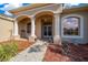 Close-up of a house featuring an arched entryway and a beautifully landscaped front yard at 14215 Presteign Ln, Spring Hill, FL 34609