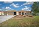 Charming one-story home featuring a well-manicured lawn and a driveway leading to a two-car garage at 14215 Presteign Ln, Spring Hill, FL 34609