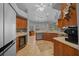 Open kitchen with custom cabinets, stainless steel appliances, wine fridge, and tile floors at 14215 Presteign Ln, Spring Hill, FL 34609