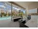 Covered patio area with comfortable outdoor seating, a beverage cooler, and views of the sparkling pool at 14215 Presteign Ln, Spring Hill, FL 34609