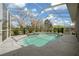 Relax in the screened in pool with a waterfall feature and an easily accessible entry on a sunny day at 14215 Presteign Ln, Spring Hill, FL 34609