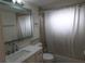 Bathroom featuring white shower curtain, a toilet and a sink with a mirror at 5641 Quist Dr, Port Richey, FL 34668
