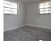 Bright bedroom featuring tiled floor, two windows and white walls at 5641 Quist Dr, Port Richey, FL 34668